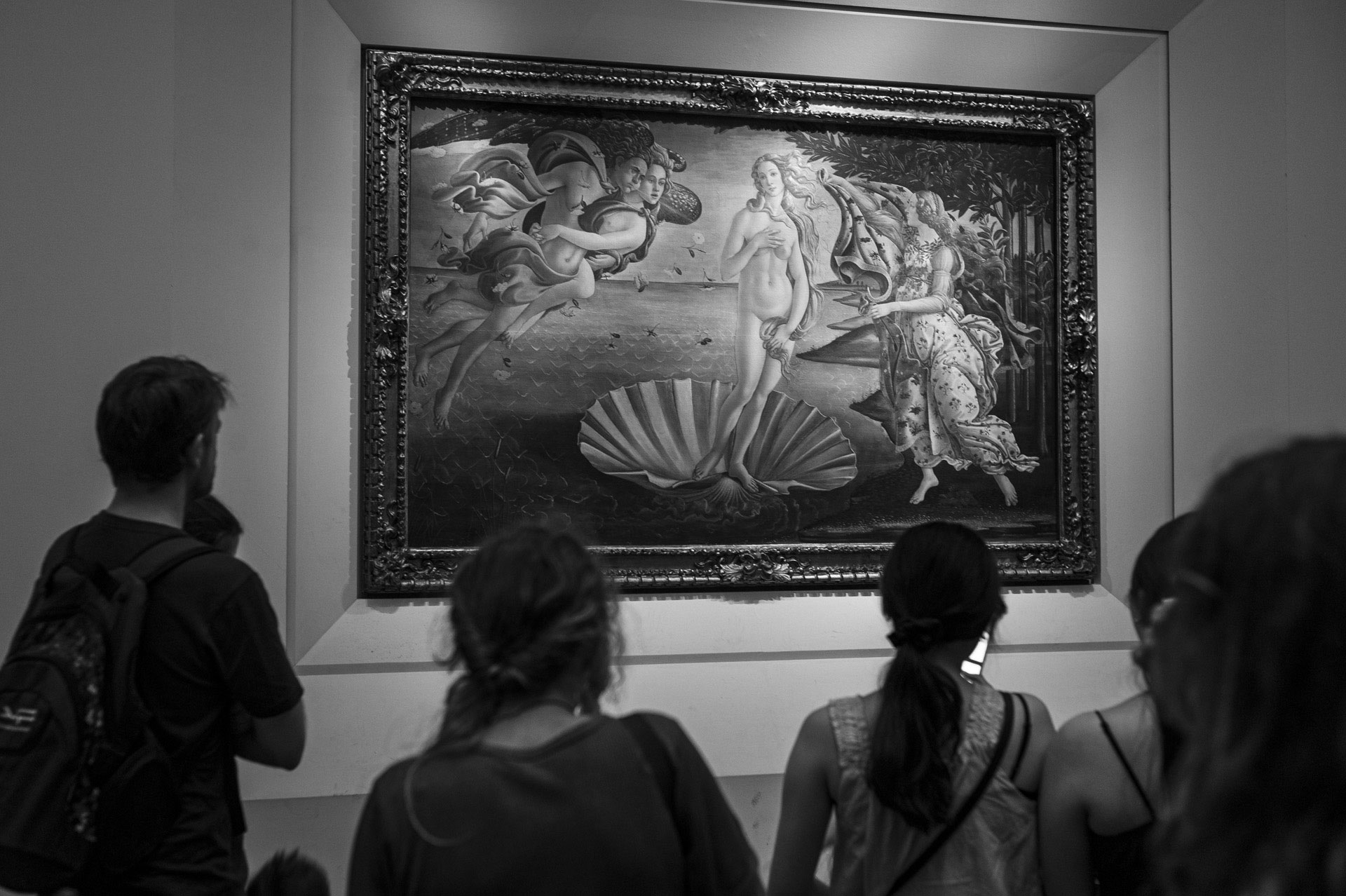 Skupina návštěvníků stojí v muzeu před slavným obrazem Zrození Venuše od Botticelliho.